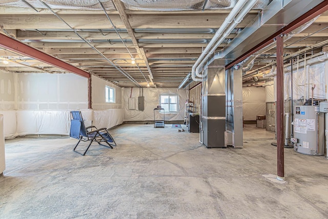 basement featuring gas water heater, electric panel, and heating unit