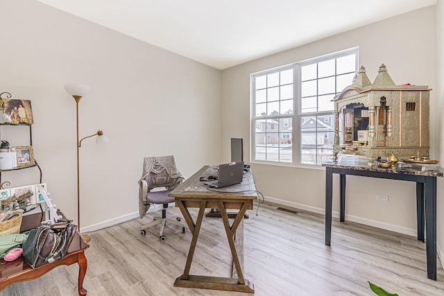 office featuring light wood-style floors, visible vents, and baseboards