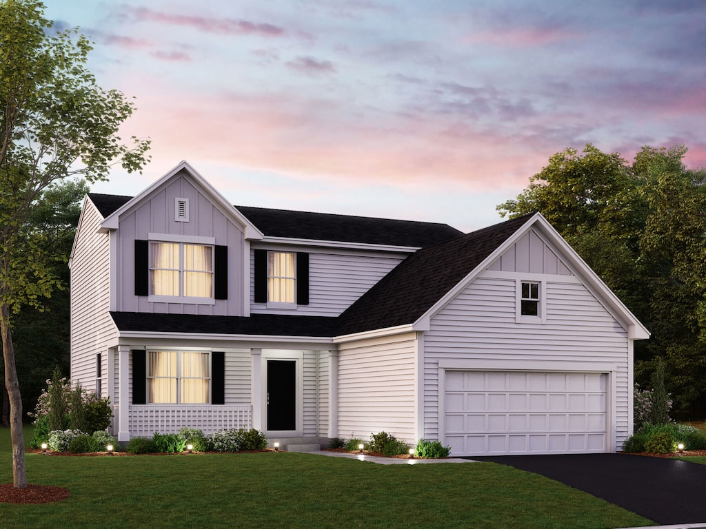 view of front of home with a garage and a yard