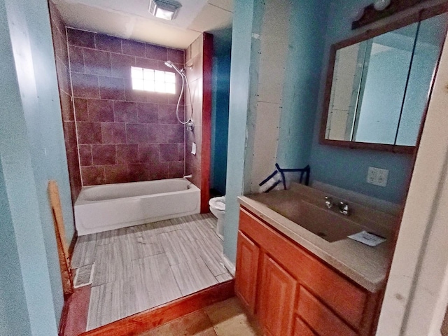 full bathroom with vanity, tiled shower / bath combo, and toilet