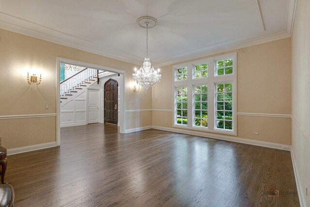 unfurnished living room with an inviting chandelier, dark hardwood / wood-style floors, and ornamental molding