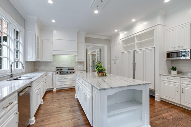 kitchen featuring white cabinets, hardwood / wood-style flooring, appliances with stainless steel finishes, and a kitchen island