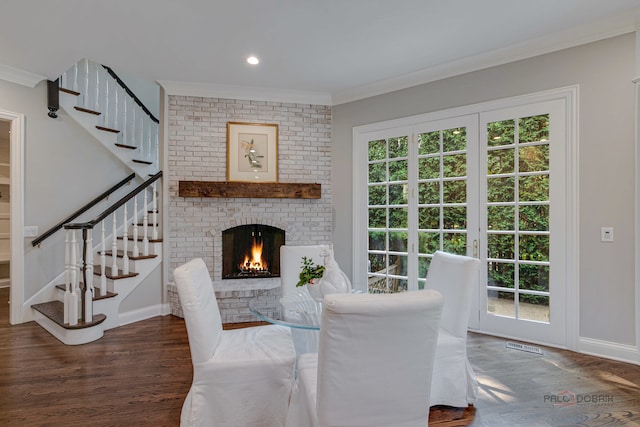 dining room featuring crown molding, dark hardwood / wood-style floors, and a brick fireplace