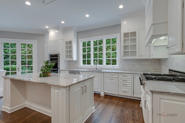 kitchen with dark hardwood / wood-style floors, a center island, tasteful backsplash, and white cabinets