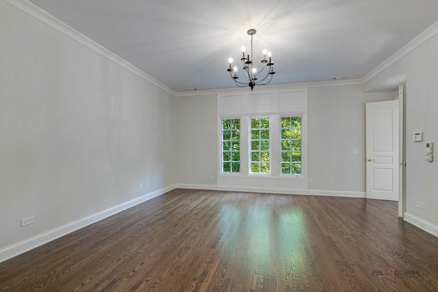 spare room featuring dark hardwood / wood-style flooring, ornamental molding, and an inviting chandelier