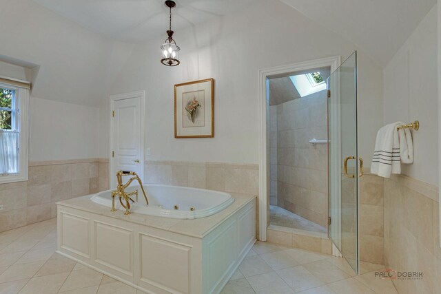 bathroom featuring lofted ceiling with skylight, tile patterned flooring, and separate shower and tub