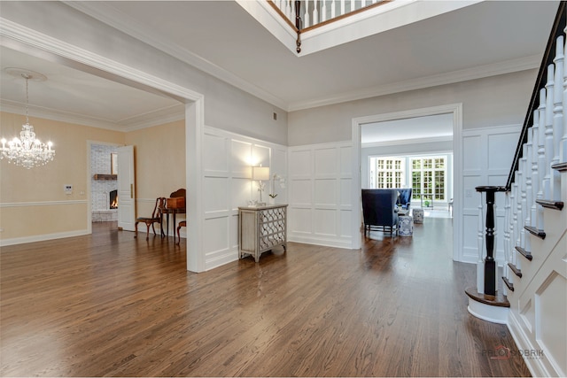 foyer with a chandelier, hardwood / wood-style flooring, and ornamental molding