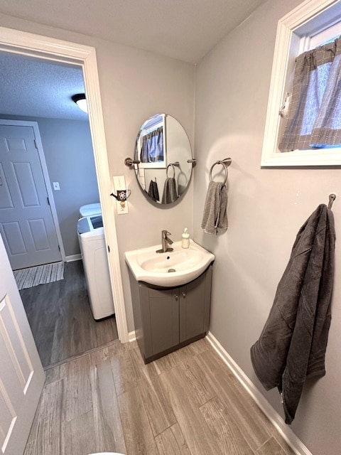 bathroom featuring wood-type flooring, toilet, vanity, and a textured ceiling