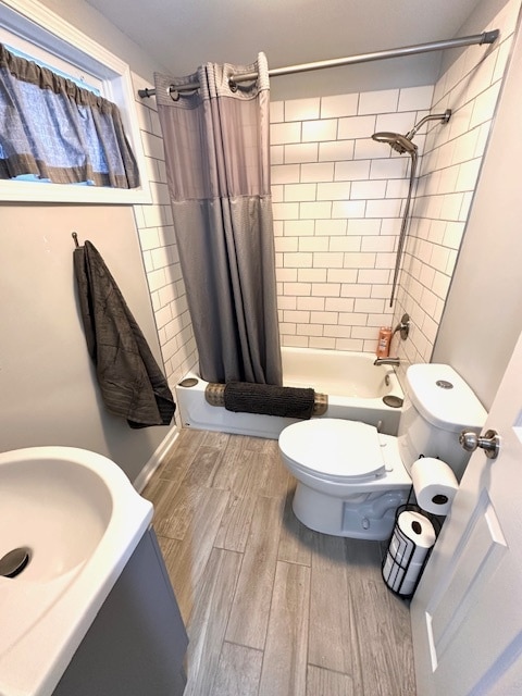 full bathroom featuring vanity, shower / tub combo with curtain, toilet, and wood-type flooring