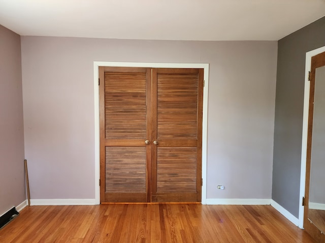 unfurnished bedroom featuring a closet and wood-type flooring