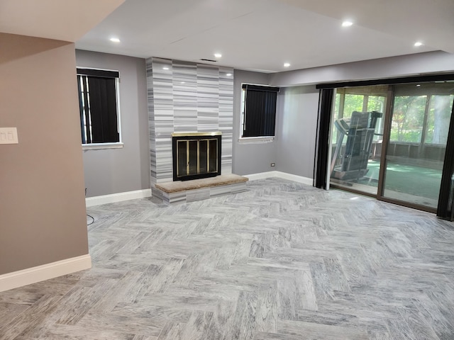 unfurnished living room featuring a large fireplace and light parquet flooring