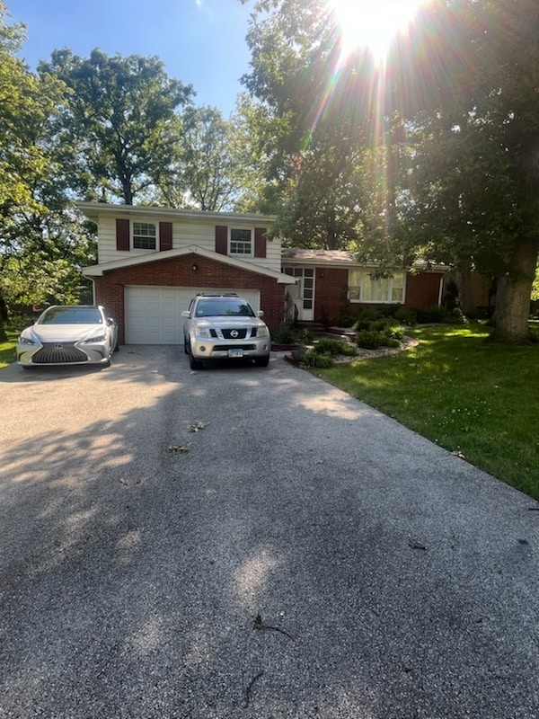 split level home with a garage and a front yard