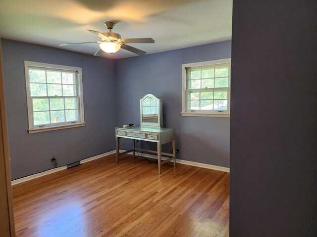 home office featuring ceiling fan, wood-type flooring, and a healthy amount of sunlight