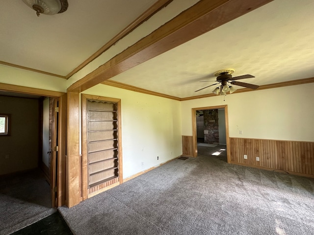 unfurnished living room featuring ceiling fan, carpet flooring, crown molding, and built in features