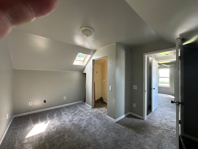 bonus room featuring carpet flooring and lofted ceiling with skylight