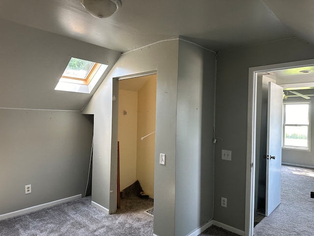 bonus room featuring carpet and vaulted ceiling with skylight