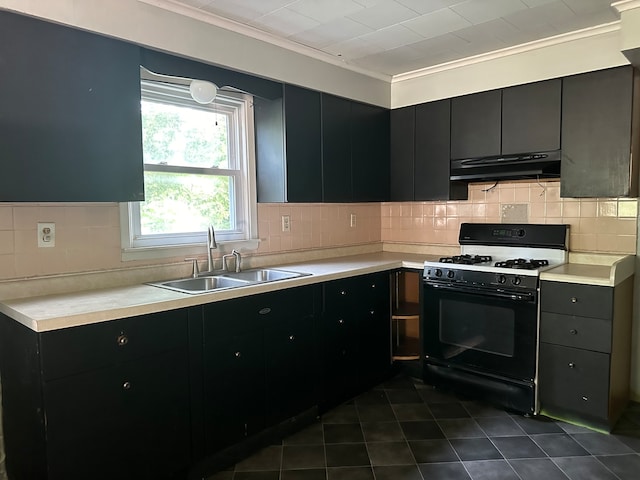 kitchen featuring dark tile patterned flooring, sink, decorative backsplash, and white gas range