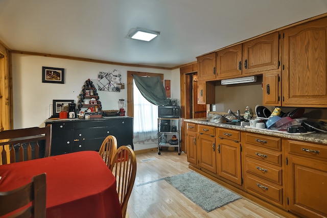 kitchen featuring sink, light hardwood / wood-style flooring, and crown molding