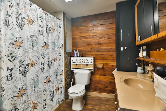 bathroom featuring vanity, wooden walls, wood-type flooring, and toilet