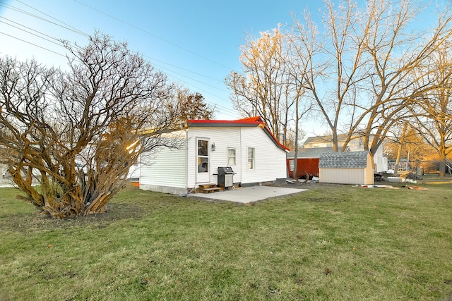 back of property featuring a storage shed, a patio, and a yard