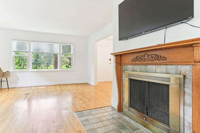 unfurnished living room featuring a healthy amount of sunlight, a fireplace, and hardwood / wood-style floors