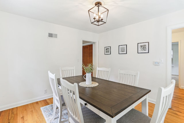 dining space with a chandelier and light hardwood / wood-style flooring