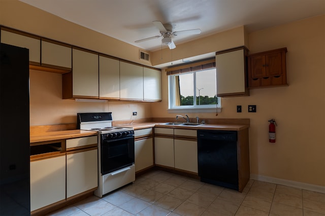 kitchen featuring light tile patterned flooring, black appliances, sink, and ceiling fan