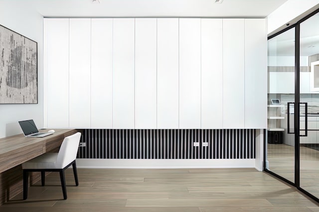 home office with light hardwood / wood-style flooring