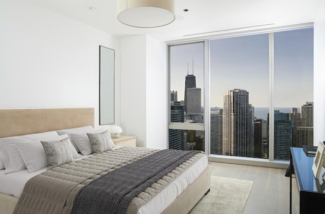 bedroom featuring floor to ceiling windows, light hardwood / wood-style flooring, and multiple windows