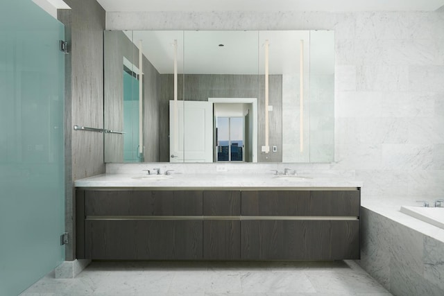 bathroom featuring a relaxing tiled tub and vanity