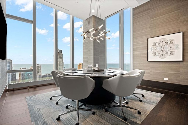 office with hardwood / wood-style floors, expansive windows, and a notable chandelier