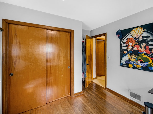 unfurnished bedroom featuring wood-type flooring and a closet