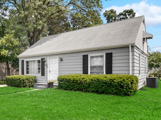 view of front of home featuring central AC and a front yard