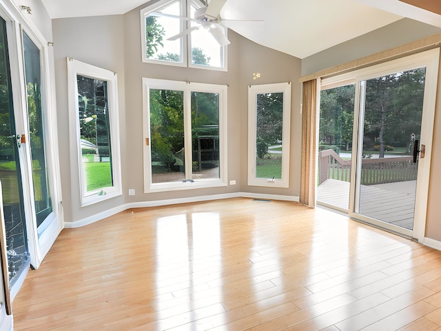 unfurnished sunroom with ceiling fan, a healthy amount of sunlight, and vaulted ceiling
