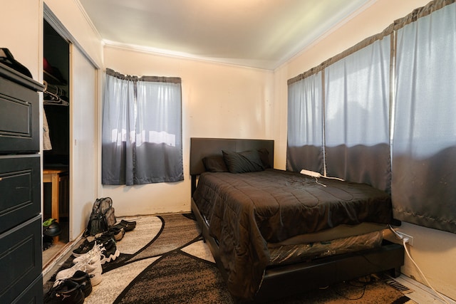 bedroom featuring crown molding, a closet, and multiple windows