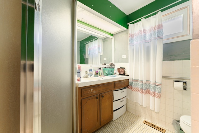 bathroom featuring tile walls, tile patterned floors, toilet, and vanity