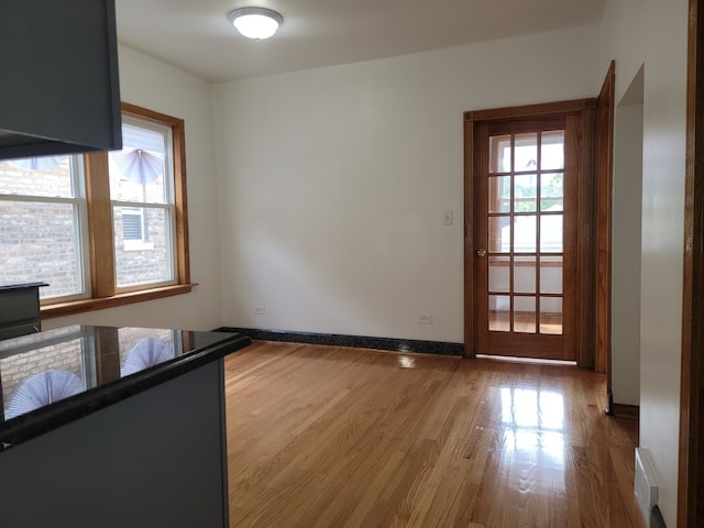 unfurnished dining area featuring hardwood / wood-style floors and a healthy amount of sunlight