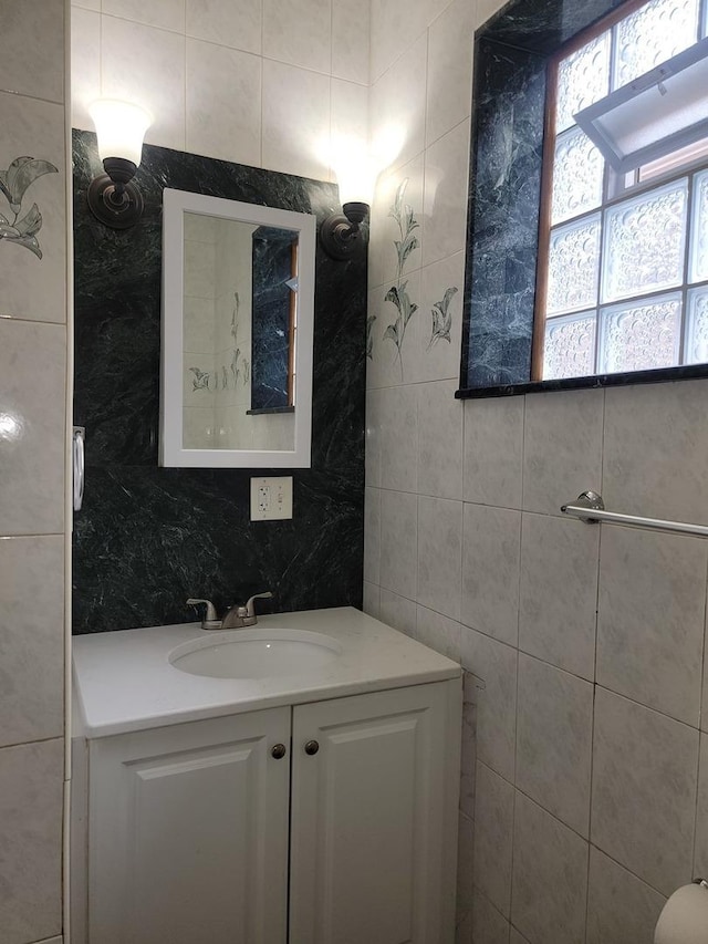 bathroom with vanity and tile walls