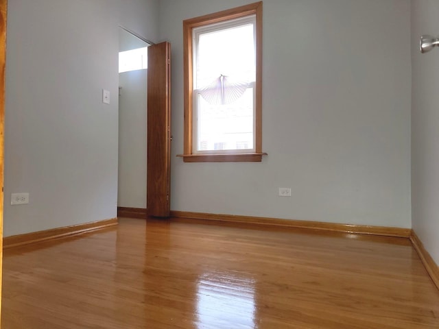 empty room with baseboards and wood finished floors