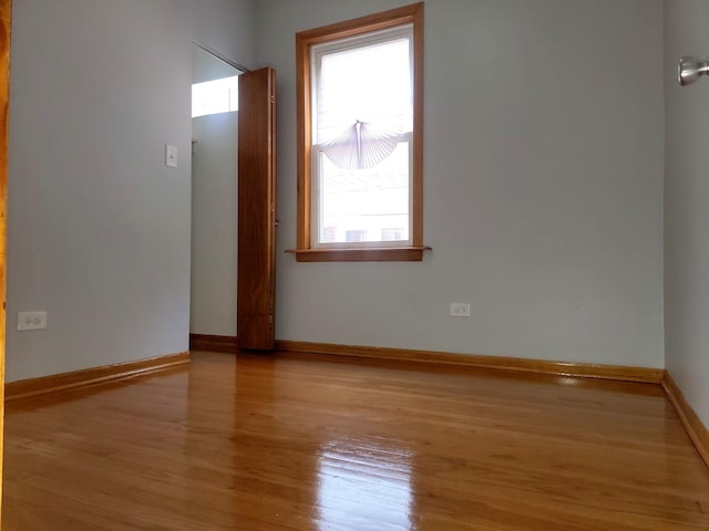 spare room featuring baseboards and wood finished floors