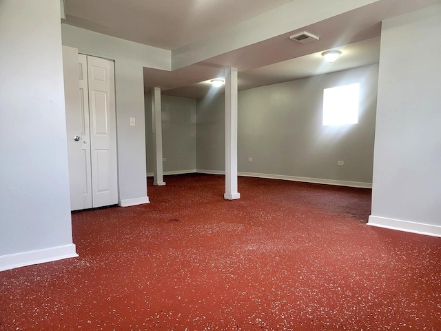 below grade area with carpet floors, visible vents, and baseboards