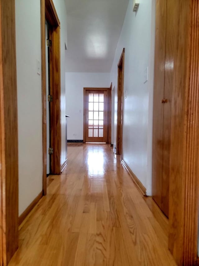 hallway with light wood finished floors and baseboards