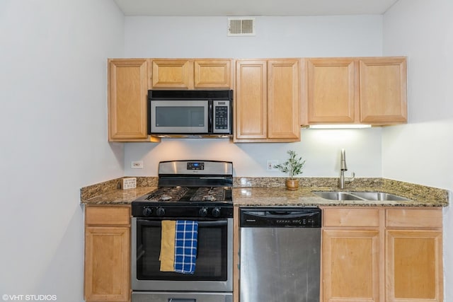 kitchen with light brown cabinets, stainless steel appliances, a sink, and visible vents