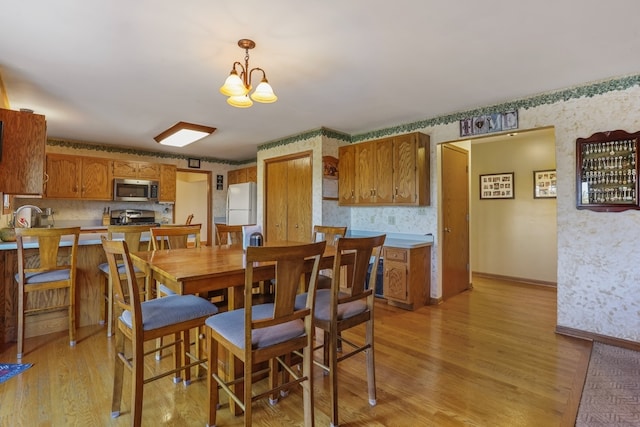 dining room featuring light hardwood / wood-style flooring, a notable chandelier, and sink