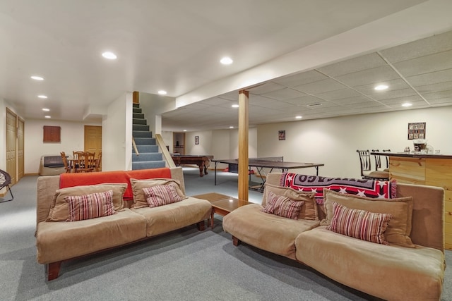 carpeted living room with a drop ceiling