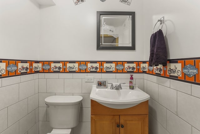 bathroom with vanity, toilet, and tile walls