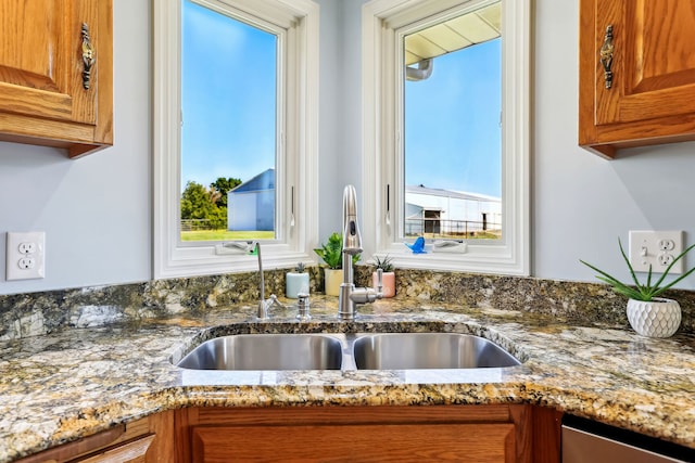 kitchen with light stone counters and sink