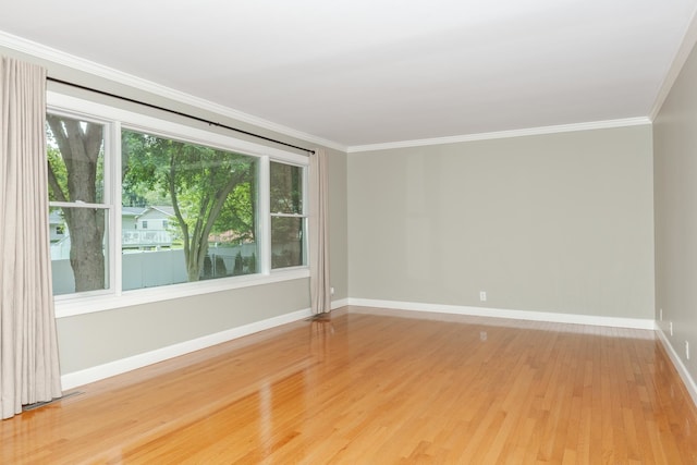 empty room with ornamental molding, light hardwood / wood-style flooring, and a healthy amount of sunlight