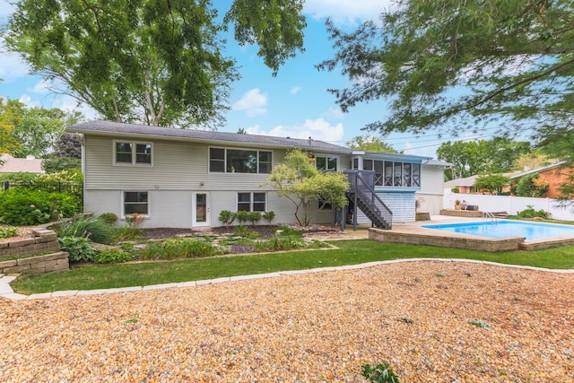 rear view of property featuring a swimming pool side deck