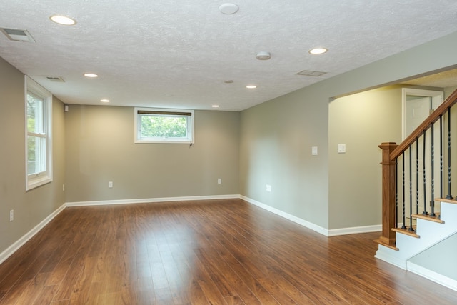 spare room featuring hardwood / wood-style flooring and a textured ceiling